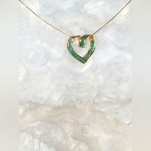 14K Heart-shaped pendant with set with emeralds.
